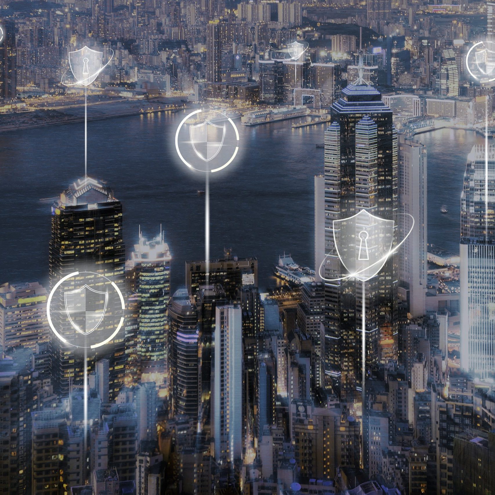 fotografía aérea de una ciudad inteligente iluminada con íconos digitales de ciberseguridad flotando sobre los edificios